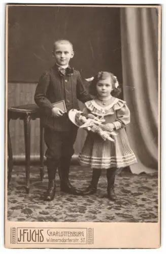 Fotografie J. Fuchs, Charlottenburg, Wilmersdorferstr. 57, Zwei Kinder mit Puppe im Arm