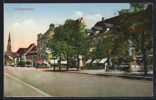 AK Offenburg, Strassenzug mit Geschäften und Kirche