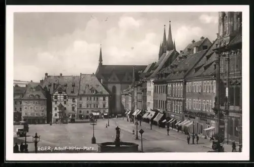 AK Eger, Platz mit Geschäften, Automobil, Brunnen, Leute