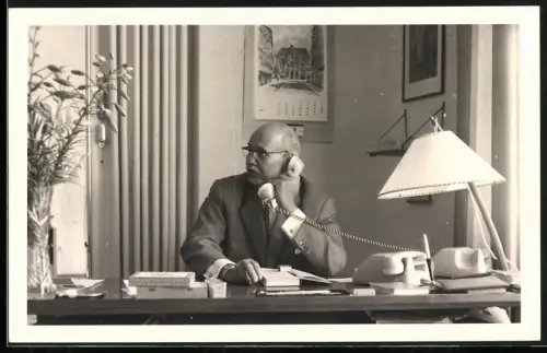 Fotografie Wirtschaftswunder, Büroarbeiter an seinem Schreibtisch beim Telefonieren