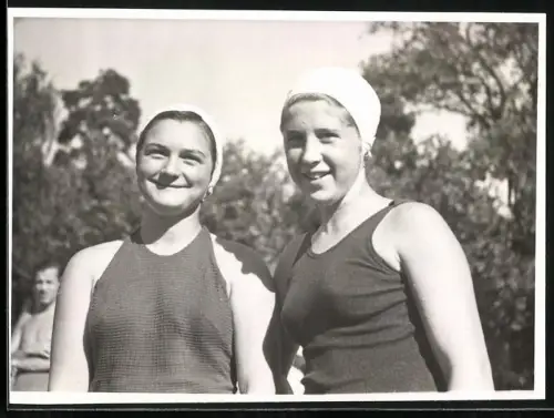 Fotografie zwei junge Frauen in Badeanzügen mit Schwimmhaube