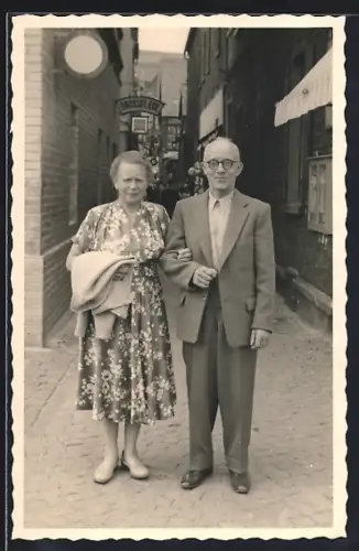 Foto-AK Rüdesheim / Rhein, Drosselgasse - Impression 50er Jahre, Älteres Paar mit Gasse und Schild vom Drossel Eck