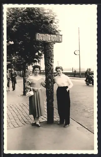 Foto-AK Rüdesheim / Rhein, Drosselgasse - Impression 50er Jahre, Junge Damen am Schild angelehnt