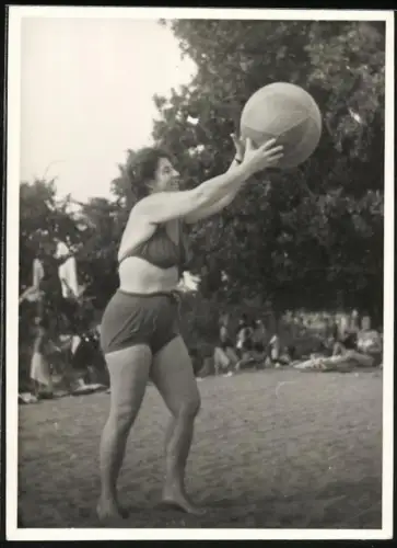 Fotografie Frau um Bikini spielt mit seinem Strandball