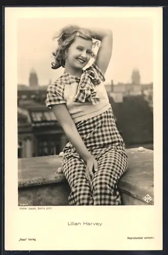 AK Schauspielerin Lilian Harvey sitzt auf einer Balkon-Brüstung