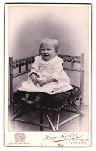 Fotografie Hugo Müller, Freiberg i. Sa., Fischerstr. 29, Porträt eines Kindes im Stuhl