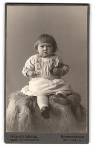 Fotografie Georg Weise, Sommerfeld, Kind auf Fell
