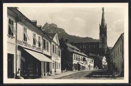 AK Admont, Strassenpartie mit Geschäften und Kirche
