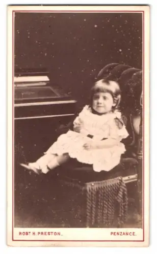 Fotografie Robt H. Preston, Penzance, Sitzendes Kind auf einem Sessel