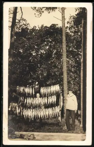 Fotografie Fischer / Angler mit seinem Tagesfang zum Trocknen aufgehangen