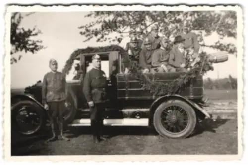 Fotografie Feuerwehrmänner in Uniform mit Helm auf geschmücktem Auto