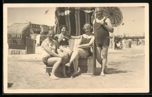 Foto-AK Zwei Männer und zwei Frauen in Bademode bei einem Strandkorb
