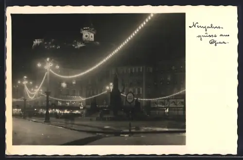 AK Graz,  Platz mit Festbeleuchtung, mit Schlossberg, Neujahrsgruss
