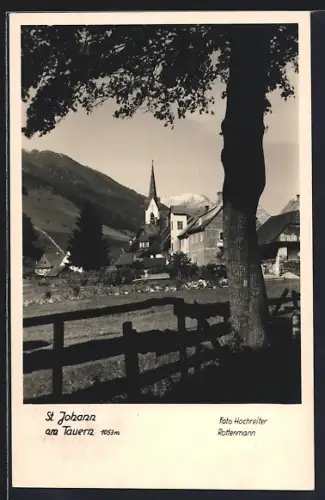 AK St. Johann am Tauern, Partie mit Baum und Zaun sowie Blick zur Kirche