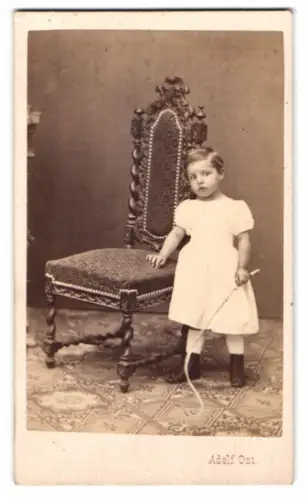 Fotografie Adolf Ost, Wien, Strauchgasse 1, Mädchen im weissen Kleidchen hält Reitgerte