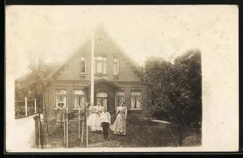 Foto-AK Grünendeich, Bedienstete im Garten vor einem Haus