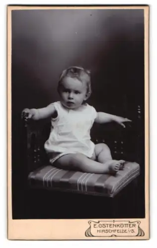 Fotografie E. Ostenkötter, Hirschfelde, Ernst Kallert als Kleinkind auf gepolstertem Stuhl