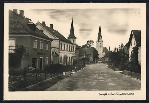 AK Strasskirchen /Niederbayern, Strassenpartie mit Geschäftshaus u. Kirchtürmen