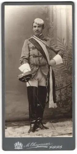 Fotografie M. Obergassner, München, Student Ernst im vollen Wichs mit Schläger und Biertönnchen, 1905
