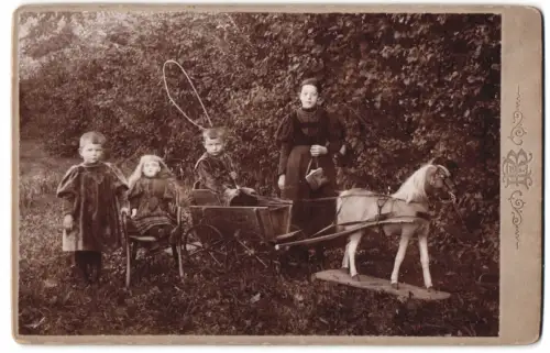 Fotografie Kinder im Garten mit Lebensgrosser Puppe und Pferd auf Rollen samt Wagen