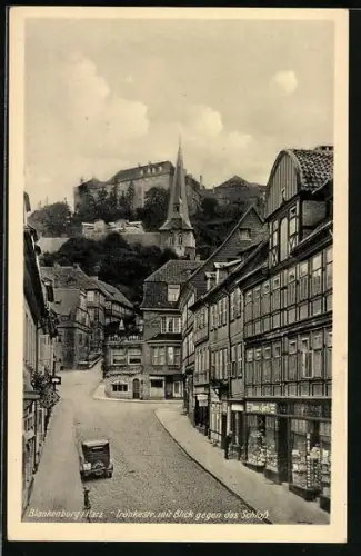 AK Blankenburg /Harz, Tränkestrasse mit Geschäften und Blick gegen das Schloss