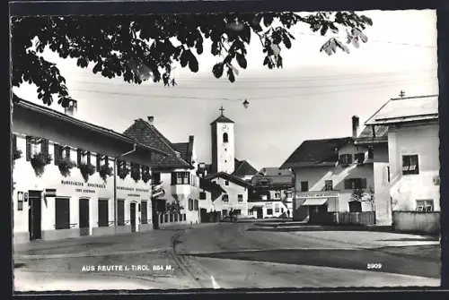 AK Reutte i. Tirol, Strassenpartie mit Modegeschäft Cenci Schennach und Kirche