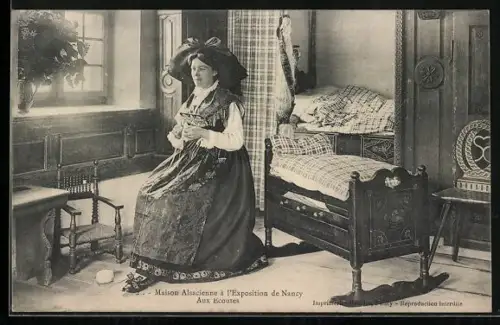AK Nancy, Exposition, Maison Alsacienne, aux ecoutes, Frau in Tracht sitzt an der Wiege