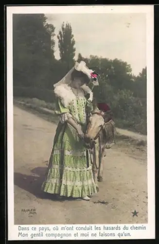 AK Dame hält einen Esel mit Sattel am Halfter