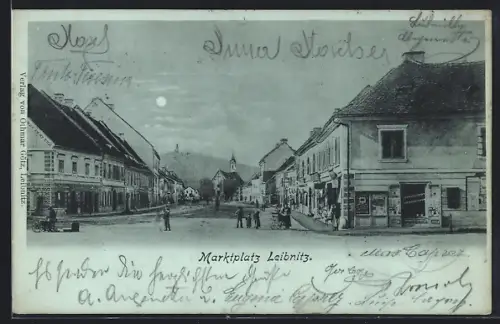 Mondschein-AK Leibnitz, Marktplatz mit Geschäften und Kirche, Panorama