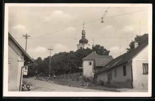 AK Dymokury, Strassenpartie mit Kirche