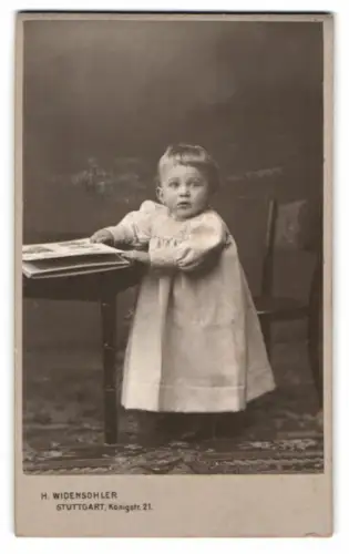 Fotografie H. Widensohler, Stuttgart, Königstr. 21, Kleinkind an Tisch mit Buch