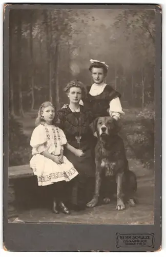 Fotografie Gebr. Schulze, Osnabrück, Mutter mit ihren Töchter und dem Familienhund vor einer Studiokulisse