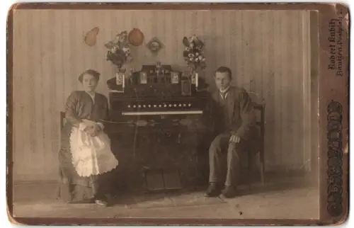 Fotografie Robert Kubitz, Bautzen, Frau und Mann mit ihrem Harmonium im Wohnzimmer