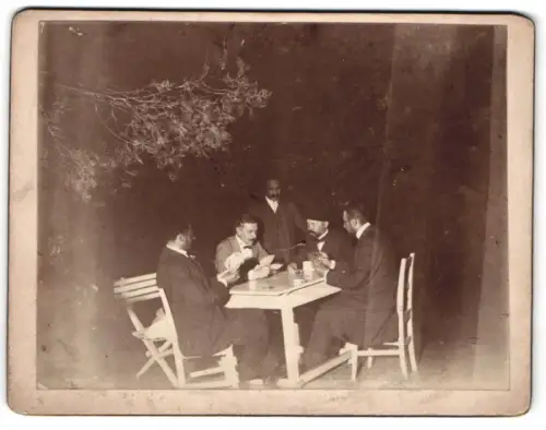 Fotografie Herren bei einer Runde Skat spielen um Bargeld