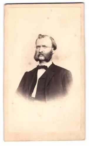 Fotografie Gebrüder Grundner, Berlin, Herr im Anzug mit Backenbart und Brille
