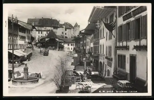 AK Gruyères, La rue avec fontaine et patisserie