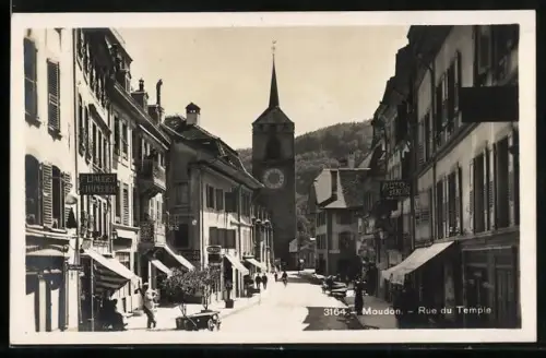 AK Moudon, la rue du Temple, le chapelier F. Liaudet, des commercants dans la rue, le clocher dans le fond