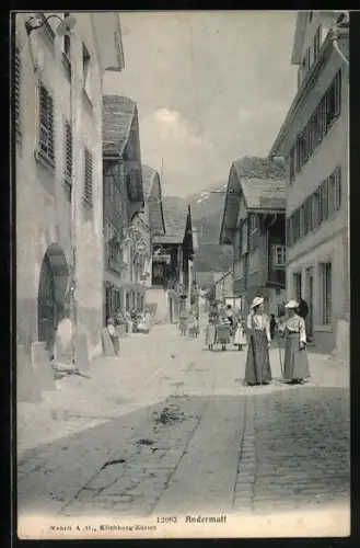 AK Andermatt, Strassenpartie mit Passantinnen in Tracht