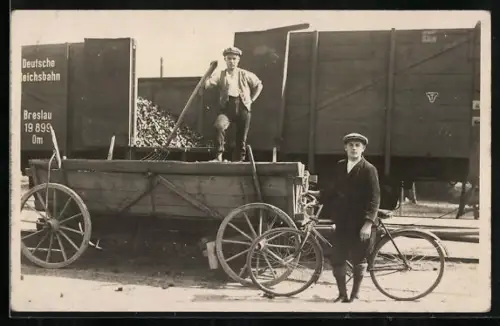 Foto-AK Mann mit Fahrrad vor einem Güterwaggon
