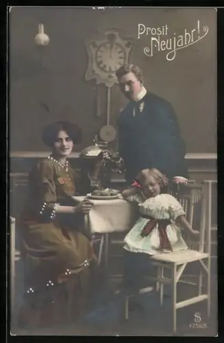 Foto-AK L.J. & F.F. Nr. 4256/5: Familie am Tisch vor Uhr, Neujahrsgruss