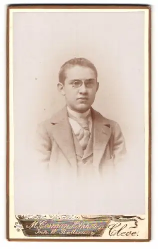 Fotografie M. Cosman, Cleve, Porträt eines jungen Mannes mit Brille