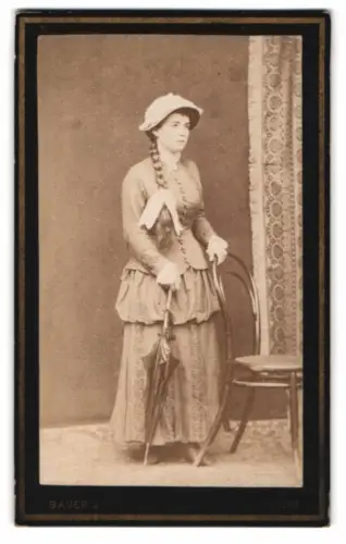 Fotografie Johann Bauer, Güns, Frau mit geflochtenem Zopf samt Regenschirm im eleganten Kleid