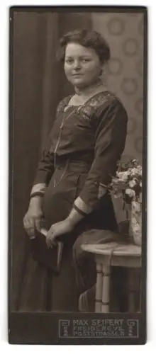 Fotografie Max Seifert, Freiberg i. S., Poststrasse 11, Frau mit Buch und Blumenarrangement