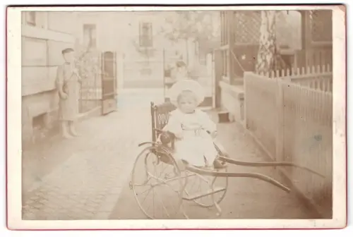 Fotografie unbekannter Fotograf und Ort, Kleinkind im Kinderwagen auf Strasse