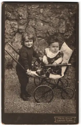 Fotografie Fritz Ohle, Lemgo, Kind mit Kinderwagen vor Steinmauer