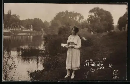 Foto-AK A. Noyer Nr. 2829: Amitiés, Junge Dame mit Album am Ufer