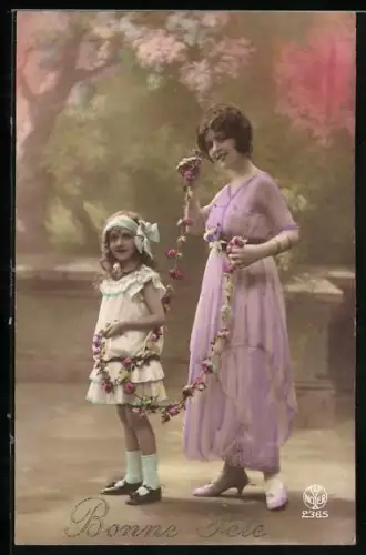 Foto-AK A. Noyer Nr. 2365: Mutter und Kind mit Blumengirlande im Park