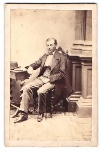 Fotografie unbekannter Fotograf und Ort, Sitzender Mann mit Tisch