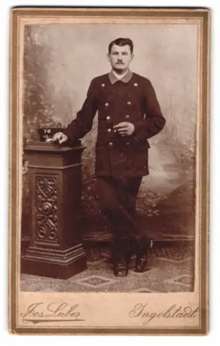Fotografie Jos. Luber, Ingolstadt, Provinzialstrasse 878, Page im Dienstanzug mit Schirmmütze samt Initialen