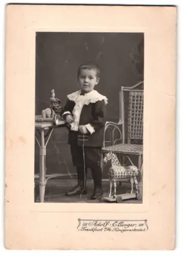 Fotografie Adolf Ellinger, Frankfurt, Königsstrasse, Porträt junger Knabe mit Spielzuegpferd und Puppen